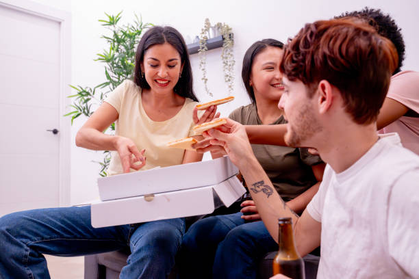 istock Friends laugh and share pizza at home. 1989698151
