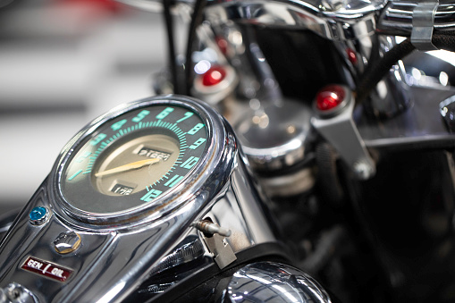 Moscow, Russia - May 04, 2019: Glossy black fuel tank of Harley Davidson motorcycle with emblem and chrome engine closeup. Moto festival MosMotoFest 2019