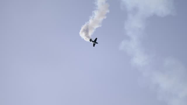 Corkscrewing Aerobatic Airplane Spiraling Down with Smoke Trail at Airshow