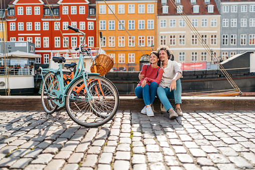Beautiful young couple relaxing in Nyhavn Canal in Copenhagen in Denmark.