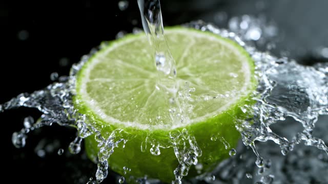 Super slow motion of fresh lime with splashing water