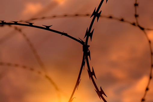 Barbed wire against sunset sky