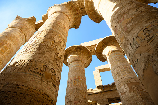 Low angle view looking up at the hieroglyphs on pillars of The Great Hypostyle Hall of the ancient Temple of Karnak at Luxor.