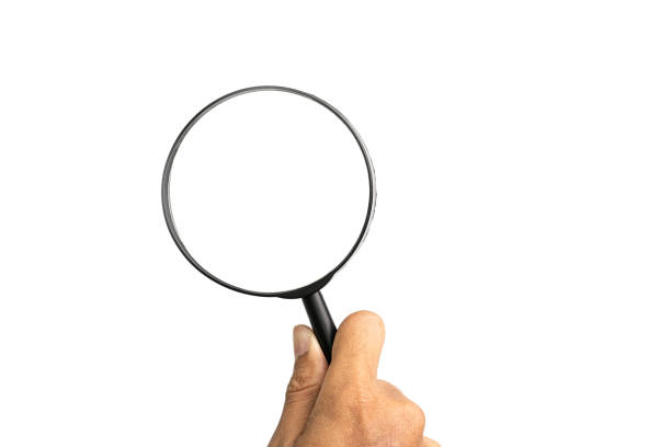 istock Hand holding magnifier tool isolated on white background. discover and research concept. 1989791624