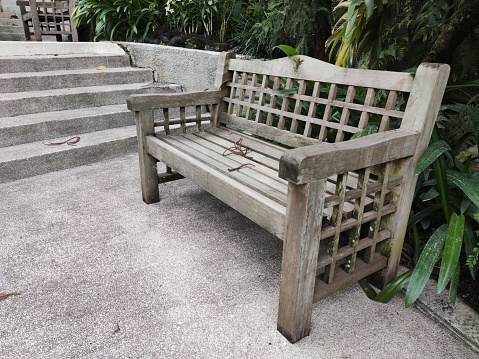 Water- and sun-resistant wooden chairs in the city park provide a comfortable and durable seating option for visitors, enhancing their relaxation experience amidst nature.