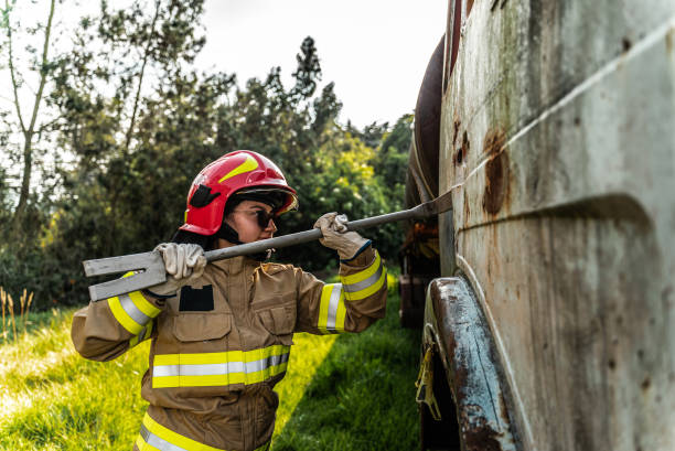 Firefighter using a crowbar to break down a vehicle door in an accident