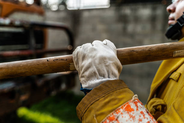 Close-up of a firefighter holding an axe or sledgehammer