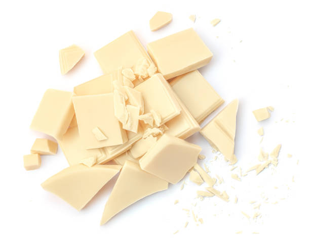 istock Broken white chocolate pieces  isolated on white background. Cubes of irregular chocolate shape for package design. Top view. Flat lay 1989838455