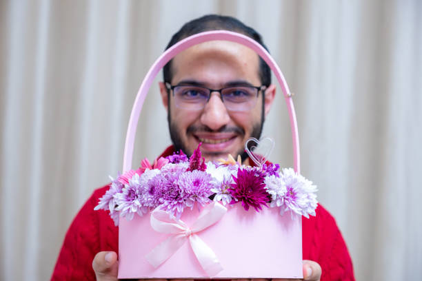 ein junges männchen hält rosa rosen in der hand und schenkt sie zum valentinstag und muttertag - mothers day mother single flower family stock-fotos und bilder