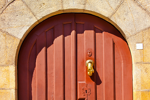 Ancient wooden front door, arch,  door knocker . Galicia, Spain.