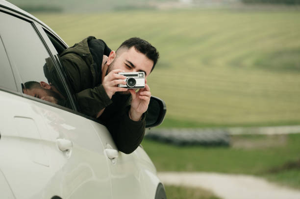 istock Man taking a picture from a car 1989849190