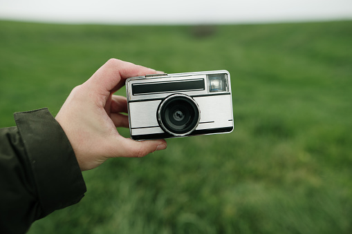 A hand holding a vintage film camera