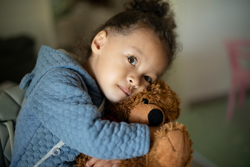 Girl, toddler and teddy bear hug for childhood, toy or love in care, support or trust at home. Adorable little kid, female person or child with cute fluffy doll, stuffy or friend in embrace or cuddle