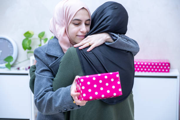istock muslim Daughter hugging and gifting her mother 1989859420