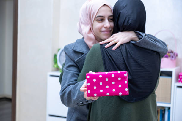 istock muslim Daughter hugging and gifting her mother 1989860003