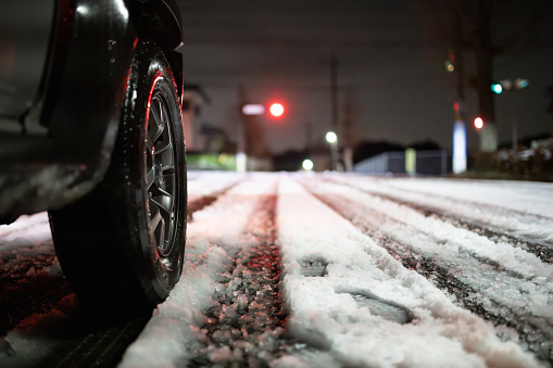 Snowy night intersection and car tires