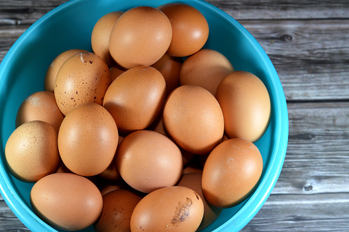 organic brown fresh and raw hen chicken eggs, stack of eggs ready to be cooked in various cuisines, red eggs which consists of egg yolk and white part albumen, selective focus