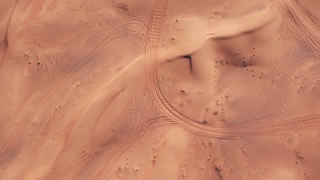The drone flies over the sand dunes of the desert