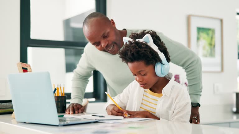 Father, child and laptop or helping with homework for elearning school at home for education, knowledge or studying. Man, son and headphones or notebook for online virtual class, tutor or development