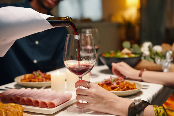 istock Man pouring red wine into wineglass 1989967864