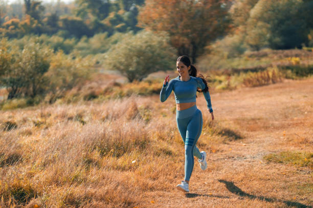 istock A confident young athletic woman running through an open grass field 1989978163