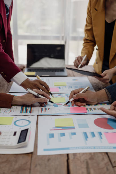 istock vertical business meeting Image Business team meeting using calculator Work with charts and analyze business strategies. financial statistics sitting at the desk vertical view 1989979226