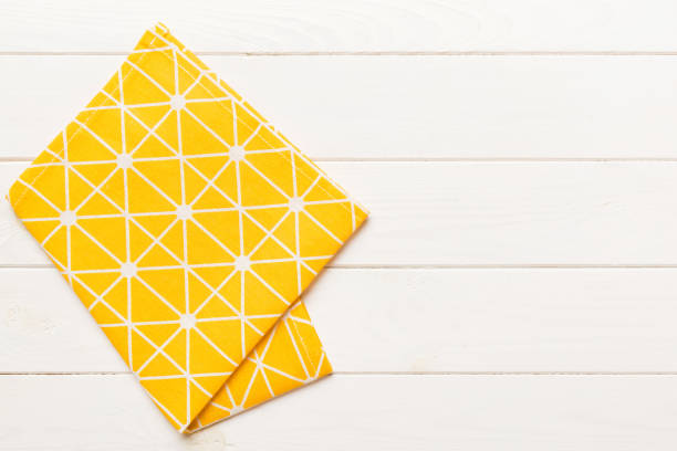 istock top view with yellow empty kitchen napkin isolated on table background. Folded cloth for mockup with copy space, Flat lay. Minimal style 1989981884