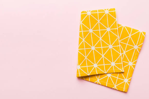 istock top view with yellow empty kitchen napkin isolated on table background. Folded cloth for mockup with copy space, Flat lay. Minimal style 1989981897