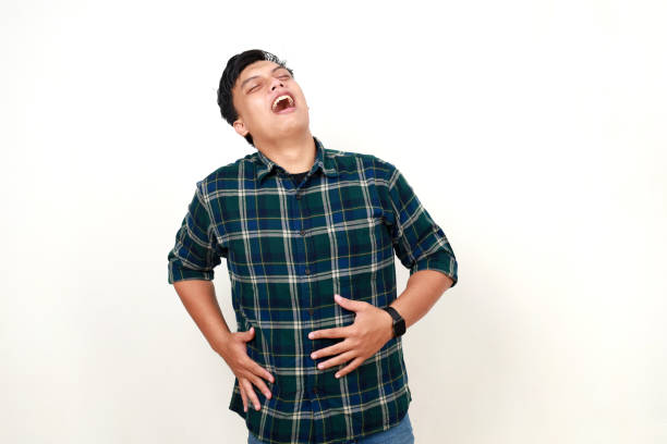 istock Young Adult Asian man touching his stomach with relieved expression 1989988340