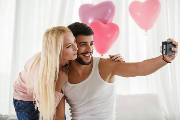 istock Smiling young man taking a selfie with his girlfriend 1989989394