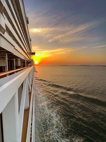 Cruise ship sailing on a calm sea towards a sunset. No people.