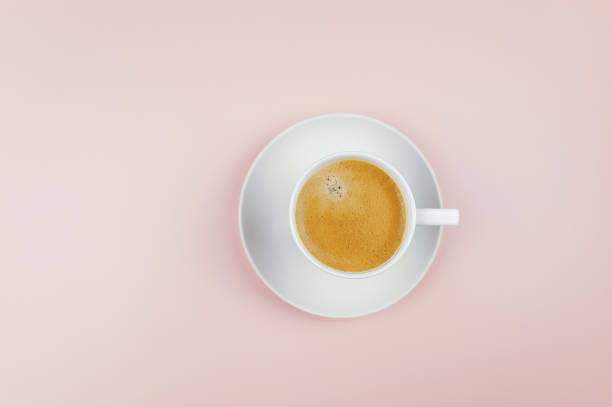 istock Top view of coffee cup on light pink background. 1989996042