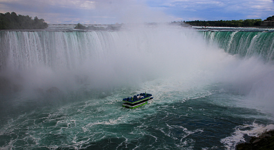 Niagara Falls, New York, USA - 30 July 2023: Tour boat moving into the mist of Horseshoe Falls inn Niagara Falls.