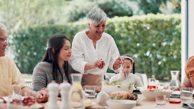 Food, outdoor and grandparents with big family or child at table in thanksgiving celebration or tradition. Salad, share or lunch with people, grandma or kid eating meal together in a social gathering