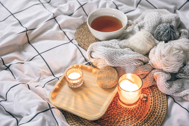 istock Cozy composition with a cup of tea, a candle and knitted elements on a blanket. 1990021691