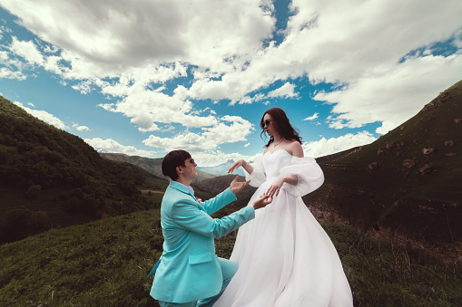 A man, a woman and a marriage proposal in the mountains. Couple, engagement and ring proposal in nature. romance, love and happiness on summer vacation