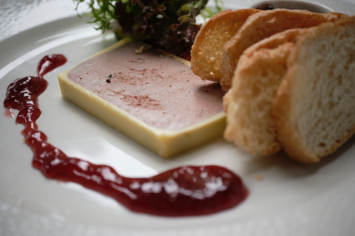 Close up of a Restaurant Starter, pate with slim toasted bread.
