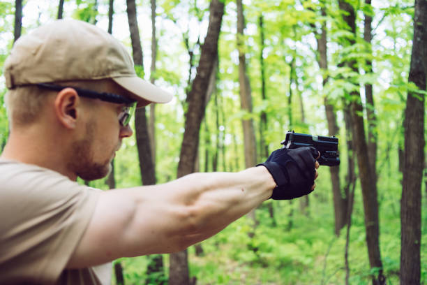istock instructor with gun in forest leads aiming and posing on camera 1990069787
