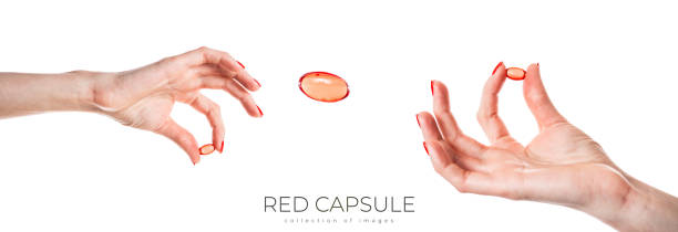 istock Hand holding a red capsule isolated on white background. Red pill isolated. 1990085046
