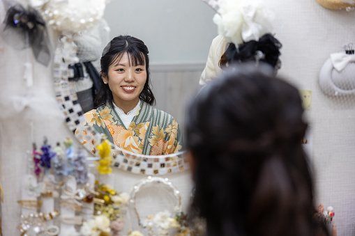 Woman in Kimono / Hakama sitting in front of mirror in rental kimono shop
