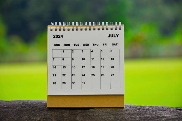 istock July 2024 white calendar with green blurred background. 1990126071