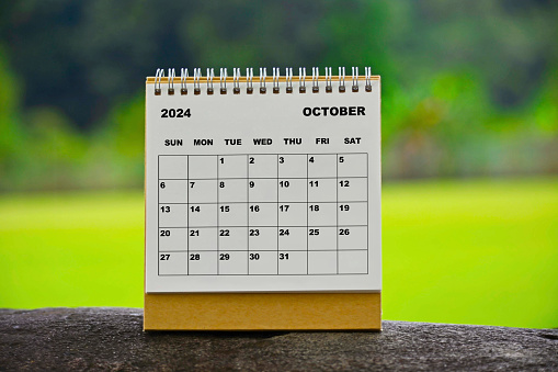 October 2024 white calendar with green blurred background - New year concept.