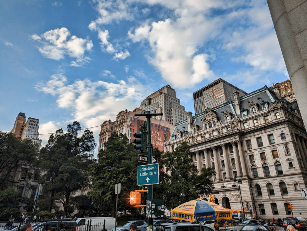New York, USA - October 10, 2023. View of a historic district in the heart of Manhattan in New York. In the foreground, vehicles and pedestrians walking on the streets are visible. In the background, the historic buildings of Manhattan are visible.