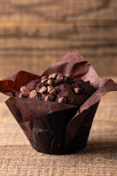 istock Chocolate dark muffin with chocolate chips and drops on a wooden table 1990143094