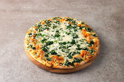 Vegetarian pizza with spinach, arugula, pesto, cheese and parmesan. Italian cuisine.