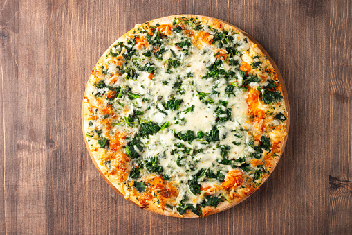 Vegetarian pizza with spinach, arugula, pesto, cheese and parmesan. Italian cuisine.