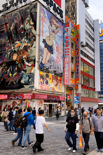 Tokyo, Japan, April 29 2023  - Image of a pedestrian street  in Ahikabara, colourful hentai semi erotic advertisiing and images visible as well as pedestrians