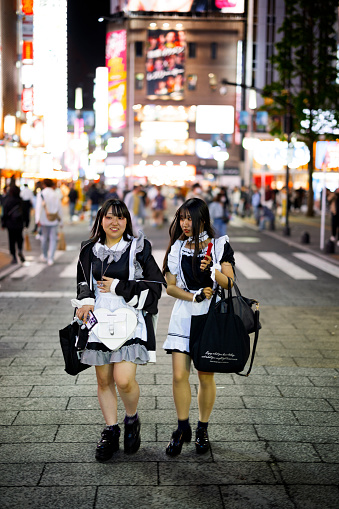 Tokyo, Japan, April 30st, 2023  - Night image of two young women wearing cosplay uniforms, Shinjuku