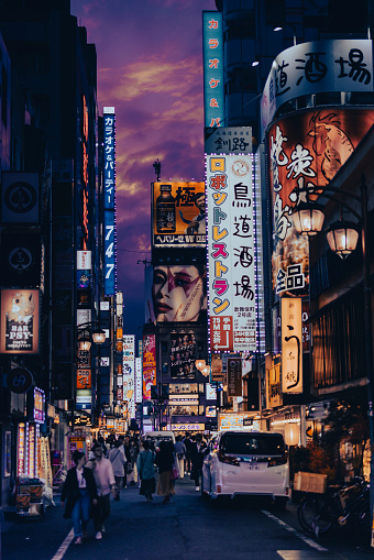 Tokyo, Japan, April 30st, 2023  - Night image of a Shinjuku street, many colourful advertisement and people walking the street