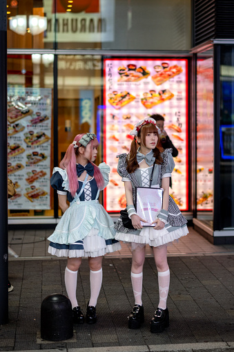 Tokyo, Japan, April 30st, 2023  - Night image of two young women wearing cosplay uniforms, Shinjuku